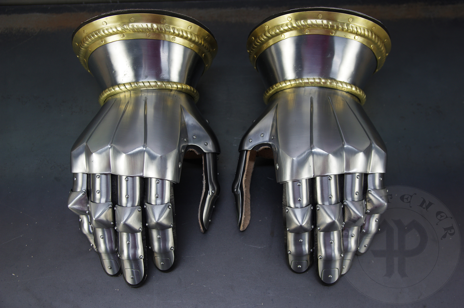 Hourglass gauntlets forged without welding from medium carbon steel, heat hardened and tempered up to 42 HRC. Fingers in articulated construction inspired by finds from Sweden. Brass decoration with roping motive./Rkawice klepsydrowe wykonane bez spawania ze stali redniowglowej, hartowane i odpusczane do 42 HRC. Palce w konstrukcji segmentowej wzorowane na znaleziskach ze Szwecji. Mosine dekoracje z motywem linowym.